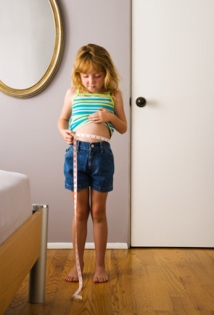 young girl measuring waist