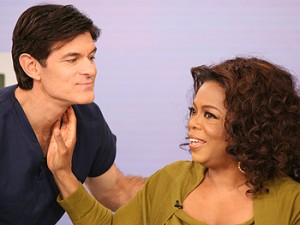 Picture of Oprah Winfrey checking the pulse on the throat of Dr. Oz