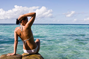 Woman in white bikini by the ocean
