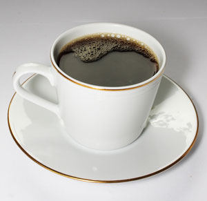 small white cup of coffee on a saucer