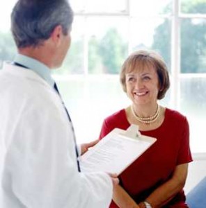 physician with clipboard with woman sitting down