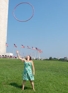 woman trowing hula hoop into the air